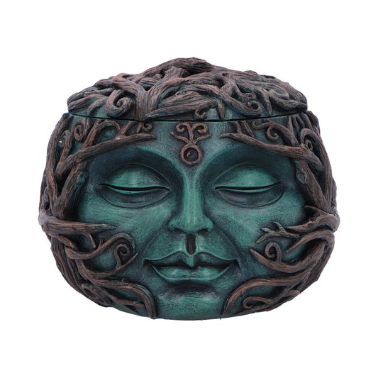A round, intricately designed green and brown sculpture features a serene face with closed eyes. The face is adorned with entwined branches, giving it a nature-inspired appearance.