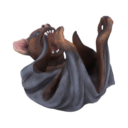 A lifelike bat sculpture is lying on its back with wings partially folded, mouth open showing teeth, in a neutral, isolated setting with a white background.