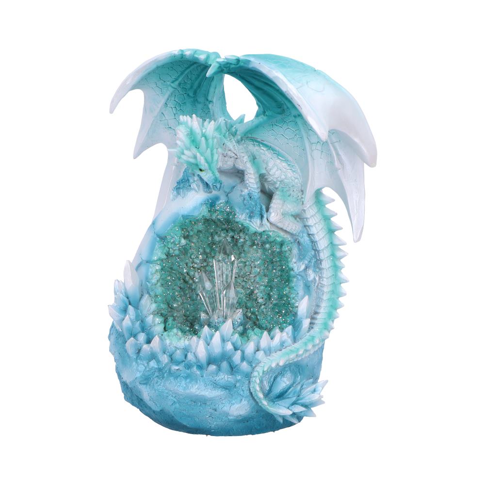 A pale blue dragon crouches protectively around a shimmering crystal cluster, surrounded by additional crystals, evoking a magical icy cave environment.
