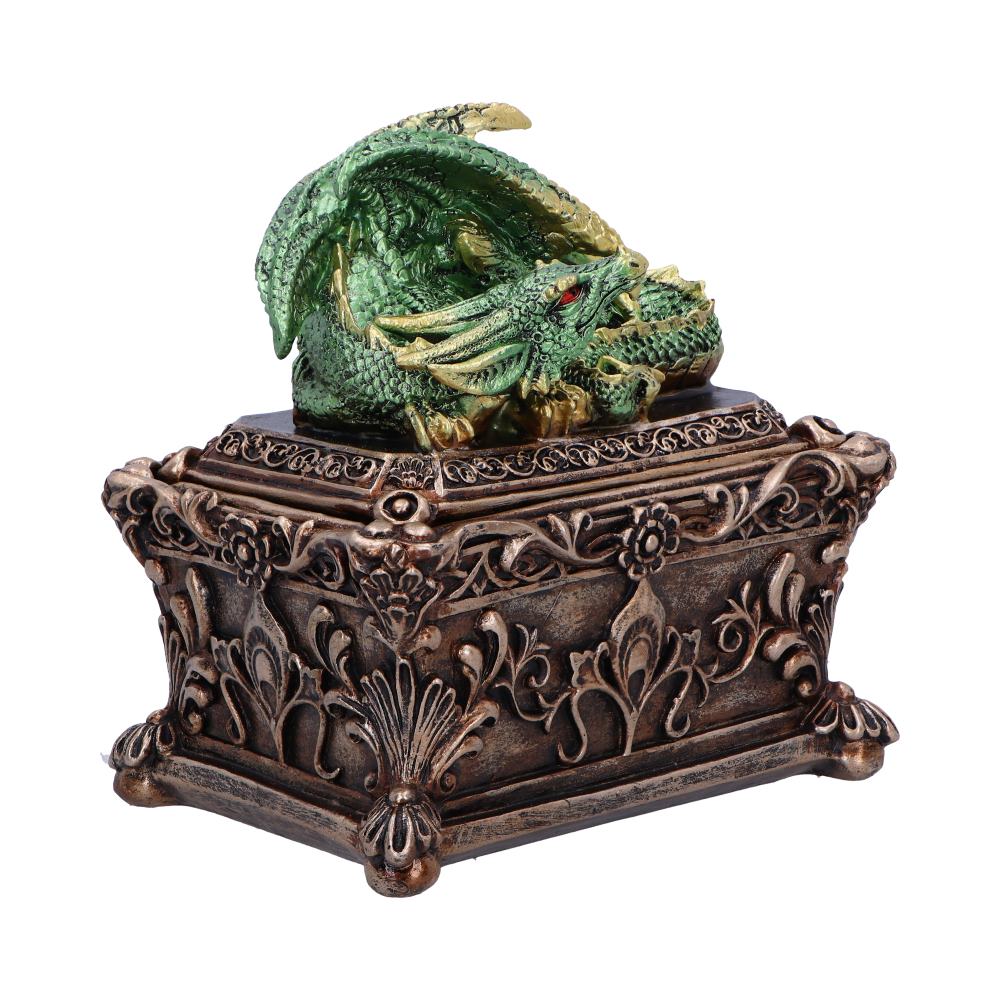 A green dragon figurine rests atop an intricately carved, ornate brown box. The box features floral and decorative patterns, enhancing its antique appearance against a white background.