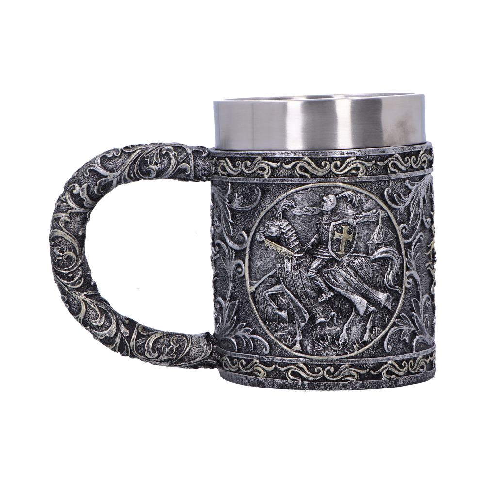 Ornate pewter style tankard shows a mounted medieval knight in relief, the carved handle and body covered in swirling floral scrollwork, with a stainless steel rim on a white background.