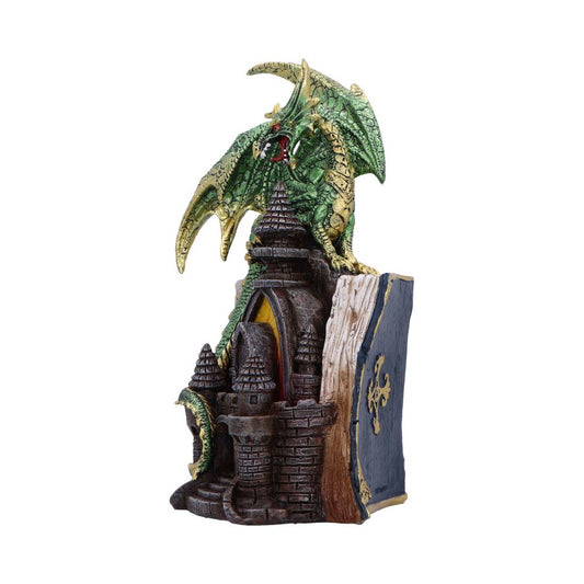 Green scaled dragon crouches and roars atop a stone castle built into a closed ornate book, its wings splayed and tail coiling around turrets against a plain white background.