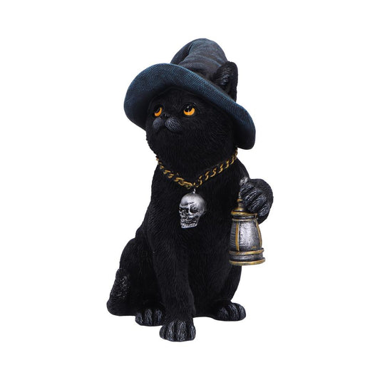 Black cat figurine sits wearing a floppy blue wizard hat, holding a lantern in one paw and a skull pendant on a gold chain, amber eyes gazing upward against white