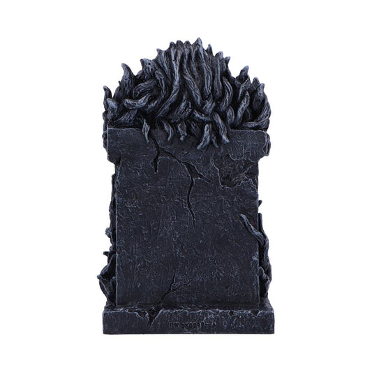 Dark cracked stone monument crowned by sculpted black flames stands upright centered against a seamless white background, textured surfaces and fissures suggesting an aged, weathered appearance