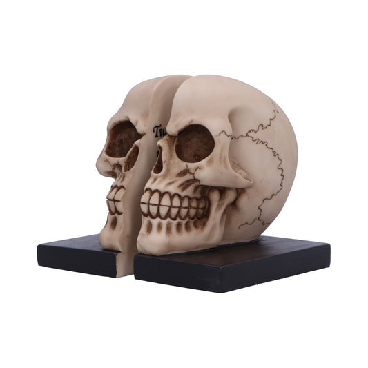 Pair of beige skull bookends sit on black rectangular bases, facing left and positioned side-by-side against a plain white background.