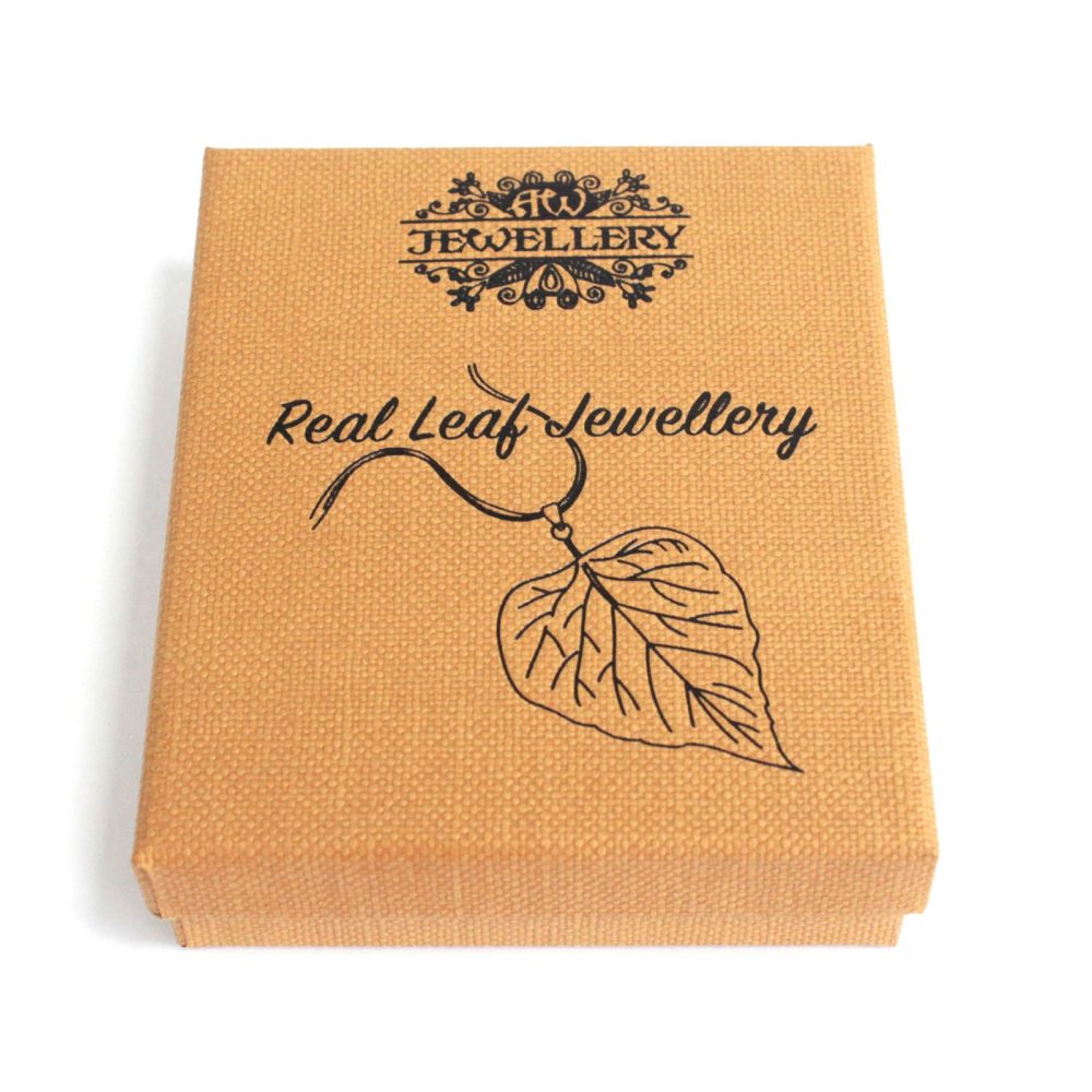 The cardboard box with a textured surface shows "Jewellery" and "Real Leaf Jewellery" with a leaf drawing and a jewelry logo on a white surface.