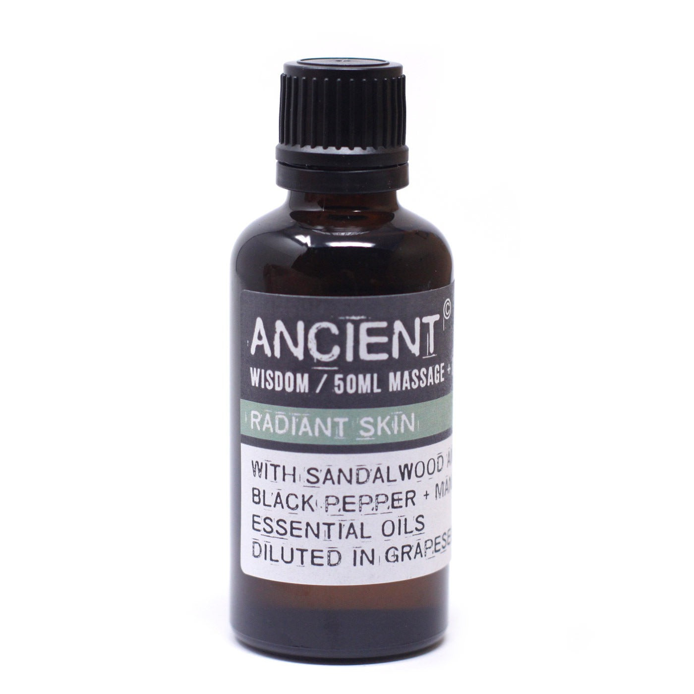 A dark glass bottle stands on a white surface, its label reading "ANCIENT WISDOM / 50ML MASSAGE RADIANT SKIN WITH SANDALWOOD BLACK PEPPER + MA ESSENTIAL OILS DILUTED IN GRAPESE."