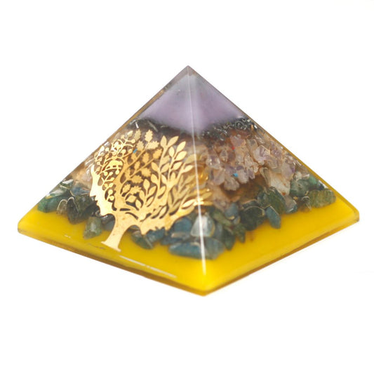 Pyramid-shaped object, with layers of yellow, blue/green, gold, clear, and purple, features a metallic tree-shaped cutout, set against a white background.