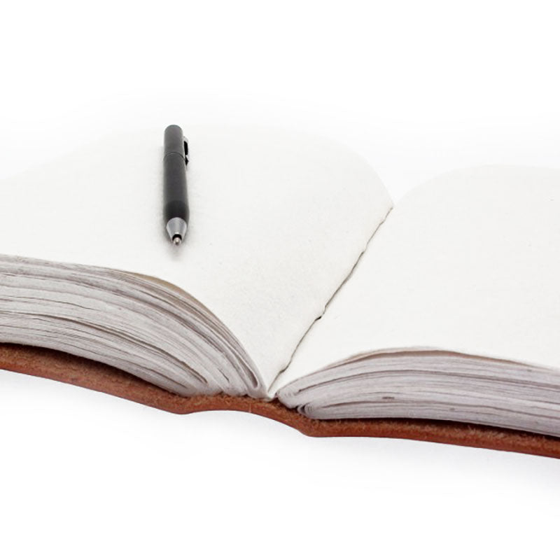 An open, leather-bound journal rests on a white surface. A black pen lies on the left page, ready for use.