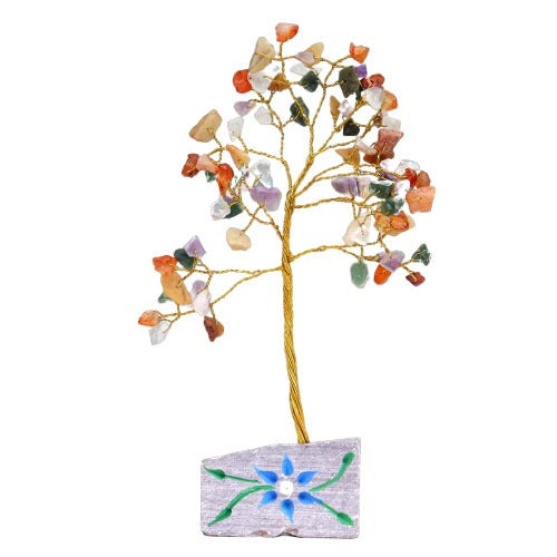 A decorative golden wire tree stands on a grey rectangular base with a blue flower design and green vines. The tree's branches are adorned with colorful gemstone chips as leaves.
