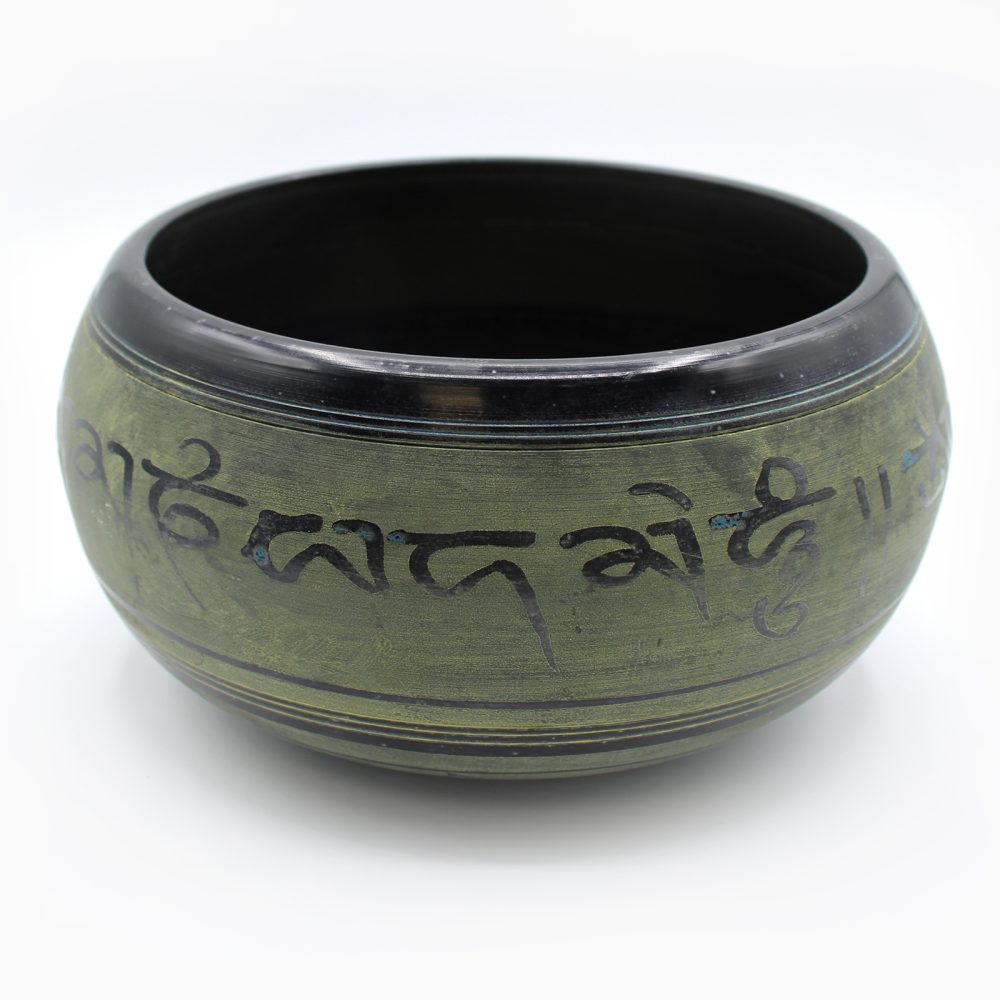A round, green bowl with intricate black script encircling its surface, sits against a plain white background. The writing includes stylized, artistic symbols.