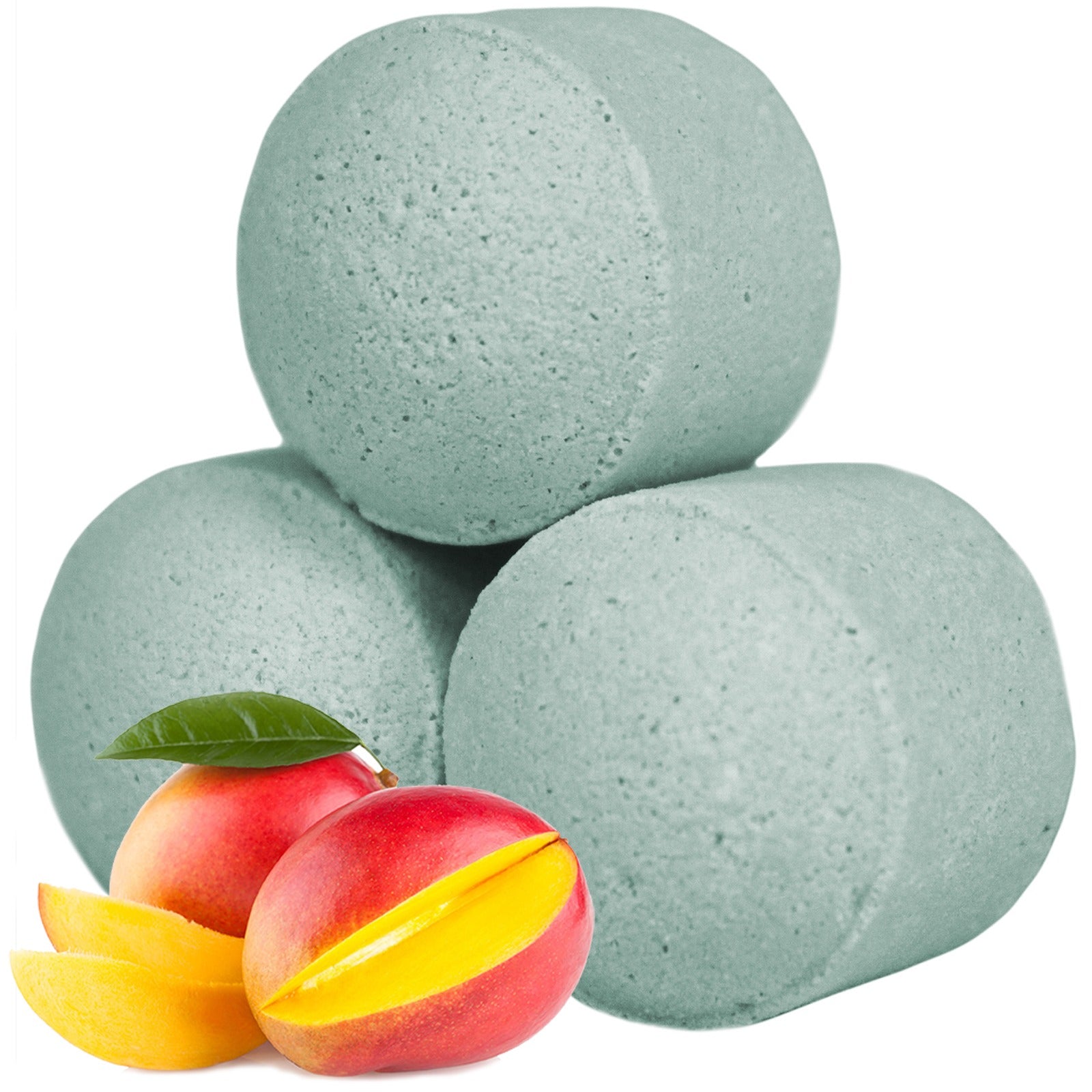Three light green cylindrical bath bombs are stacked, surrounded by a ripe mango and mango slices with a green leaf, emphasizing a fresh, fruity context.