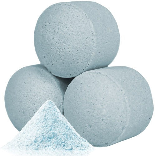 Three light blue cylindrical tablets are stacked in a pyramid formation on a white surface, accompanied by a small pile of matching blue powder in front of them.