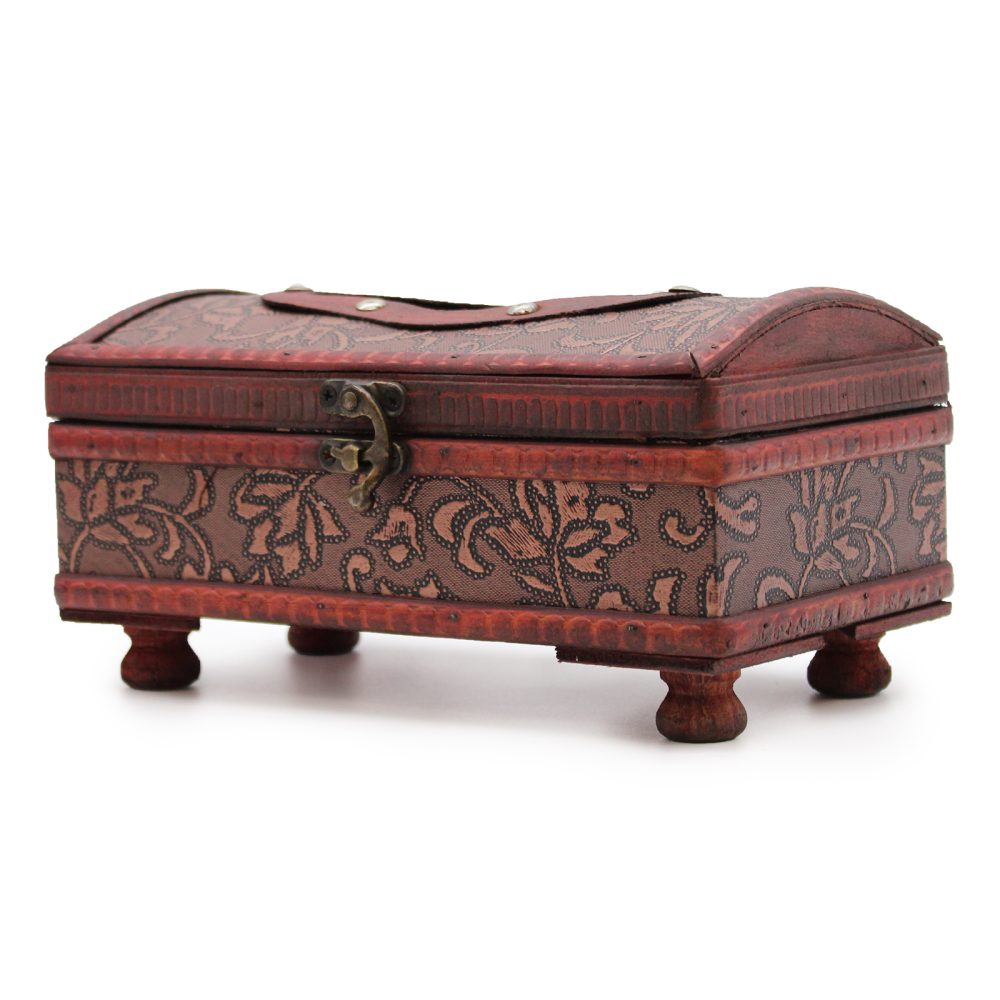 A decorative wooden box with floral patterns rests on four small legs, featuring a curved lid and a metal latch. It's set against a plain white background.