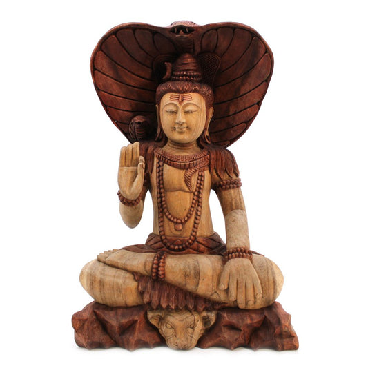 A wooden sculpture depicts a serene deity seated cross-legged, with an upright hand in a gesture of blessing. Behind, a cobra provides a protective hood, resting on a decorative base.