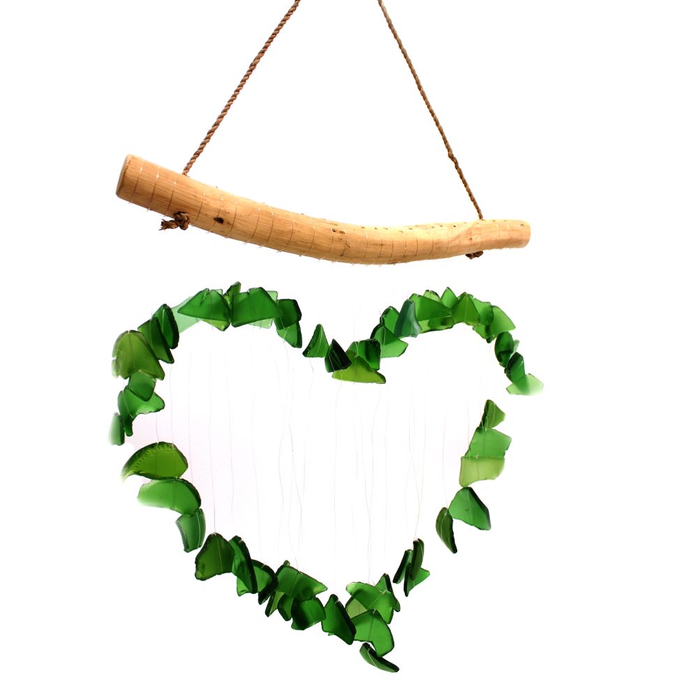 A heart-shaped wind chime, made of green glass pieces, hangs from a curved wooden piece.