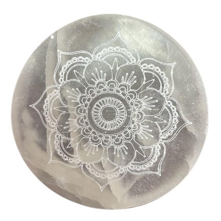 A silver-gray, round stone displays a white, etched mandala pattern. The design features concentric circles and stylized petals.