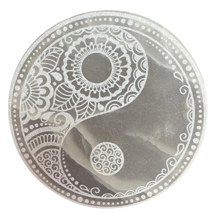 A yin and yang symbol, intricately patterned with floral designs, decorates a circular object. The design is detailed and set against a white background.