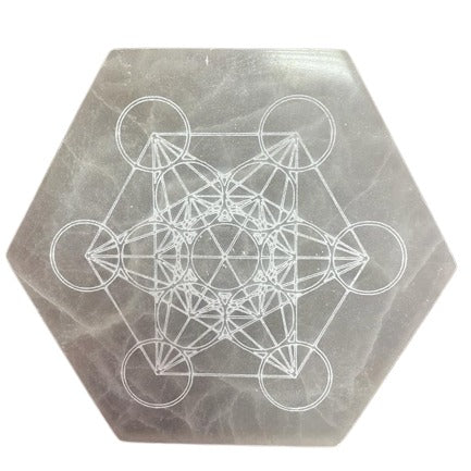 A hexagonal gray slab displays an intricate, geometric design of intersecting circles, squares, and triangles. The design is etched onto the slab's surface.