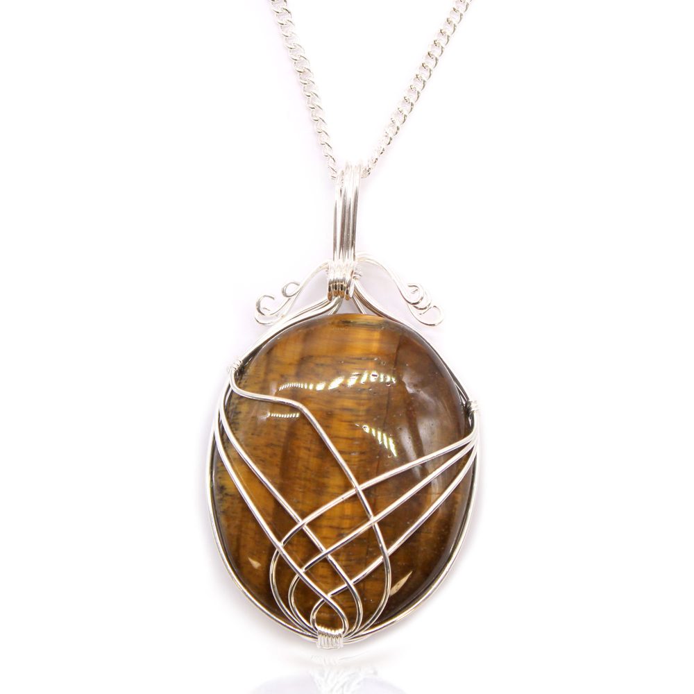 A tiger's eye stone is wrapped with silver wire and hangs from a silver chain, set against a stark white backdrop.