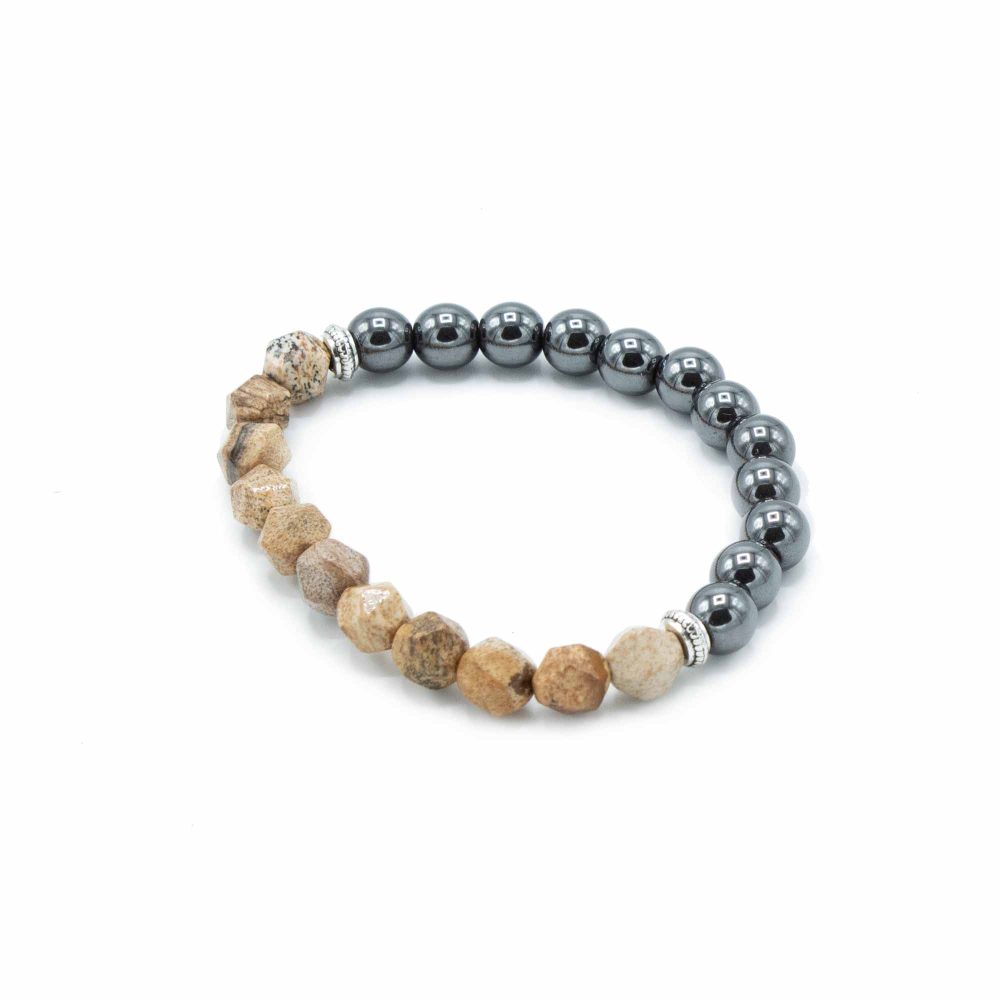 A bracelet displays a curved pattern, blending earthy, tan stones with gray, spherical beads, separated by two silver accents, on a white background.
