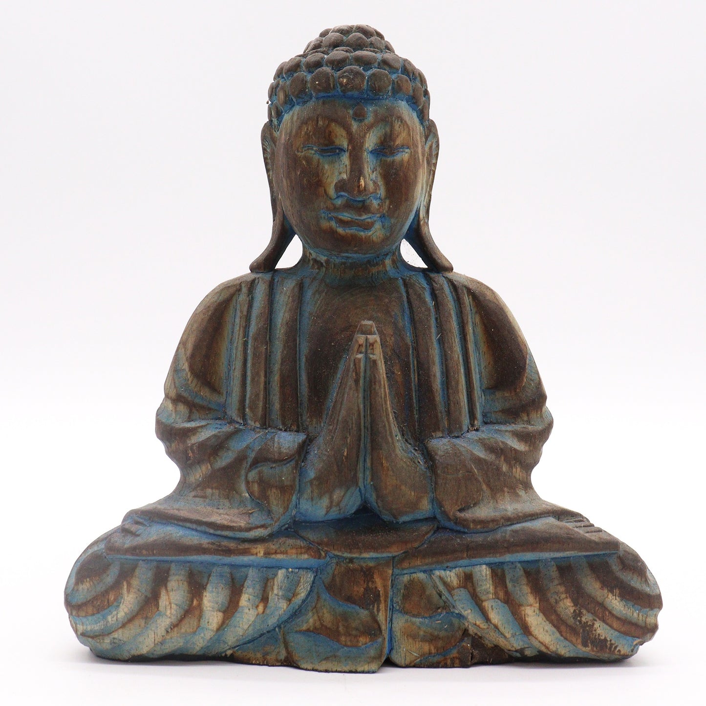 Wooden Buddha statue sits cross-legged with hands in a prayer position, adorned with a serene expression and intricate carvings, set against a plain white background.