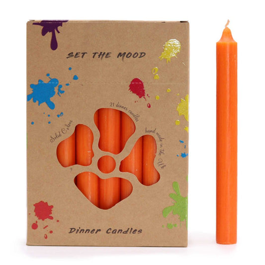 A box of "Dinner Candles" holds many, with a single orange candle sitting beside it. Text on the box reads, "SET THE MOOD," "Solid Colour," "21 dinner candles" and "hand made in the UK".