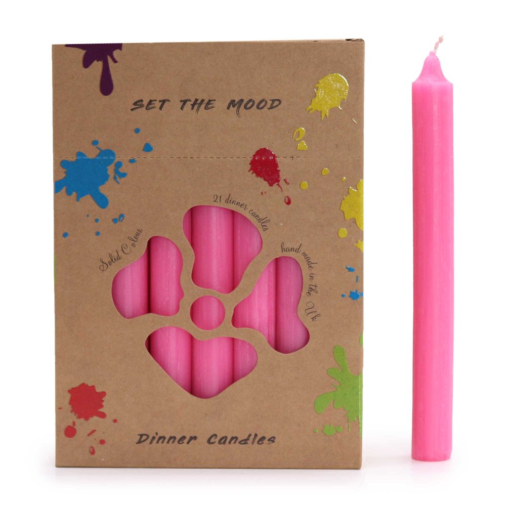 A box of pink dinner candles displays "SET THE MOOD" and "Dinner Candles" text and colorful paint splatter.  A pink candle stands next to the box, which contains 21 candles. The box reads "21 dinner candles hand made in the Uk," and "Solid Colour."