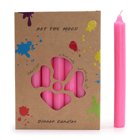 A box of pink dinner candles displays "SET THE MOOD" and "Dinner Candles" text and colorful paint splatter.  A pink candle stands next to the box, which contains 21 candles. The box reads "21 dinner candles hand made in the Uk," and "Solid Colour."