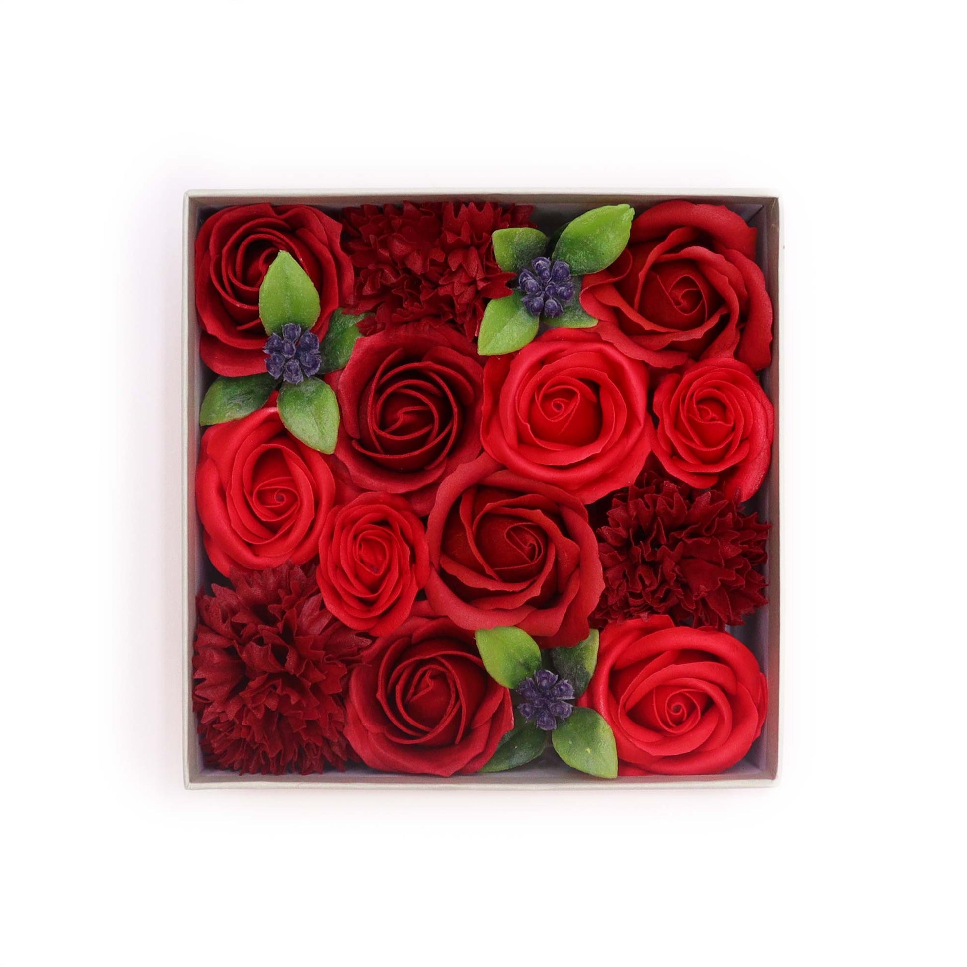 A square box contains a dense arrangement of red roses and carnations.  The flowers are meticulously positioned, creating a visually appealing, uniform pattern.  The context is a plain white background.