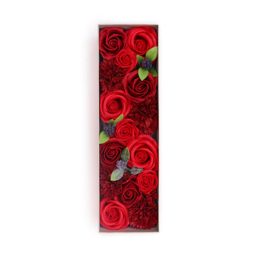 Red roses and carnations are arranged in a rectangular box, forming the letter “I” against a white background.
