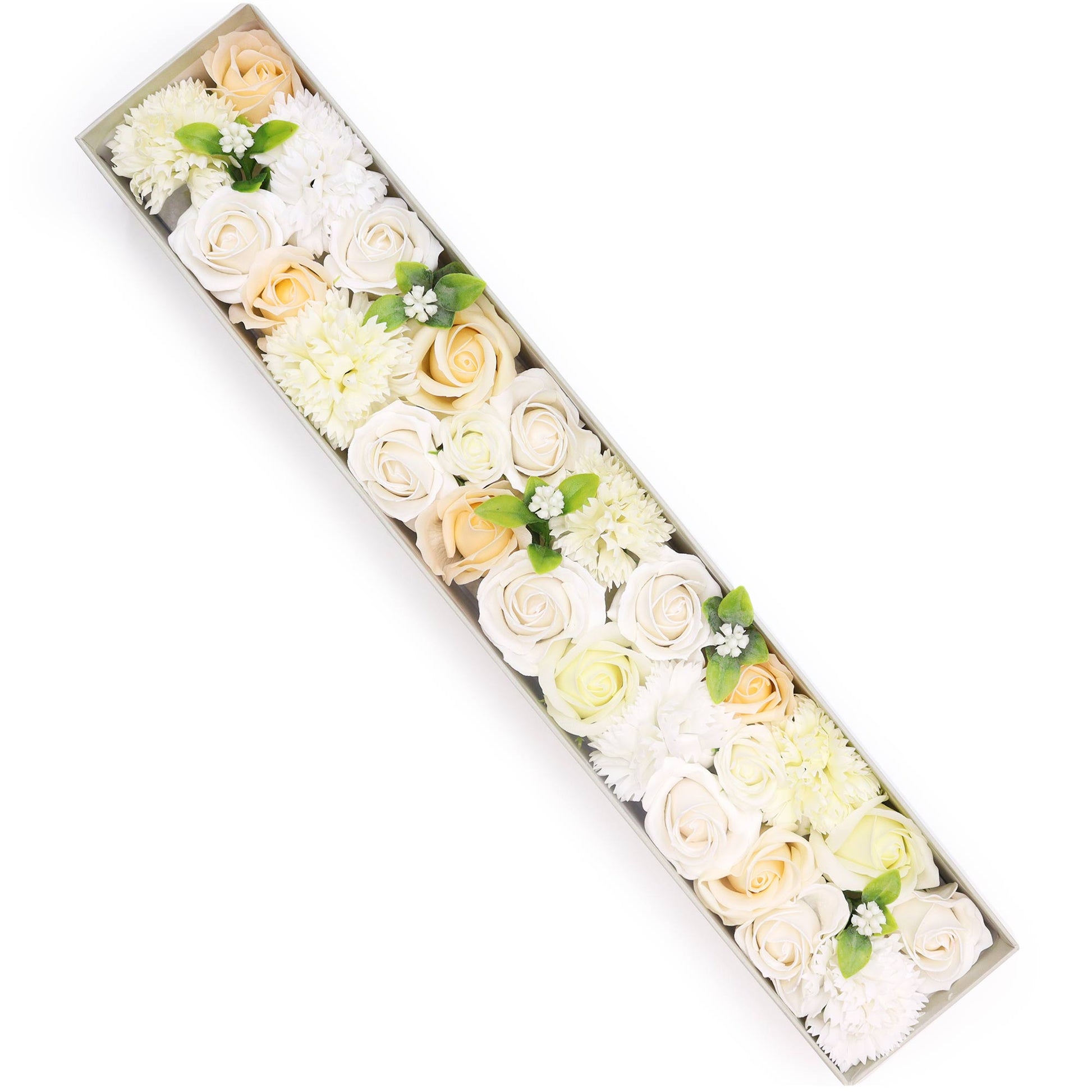 A long box contains arranged white and cream roses and chrysanthemums.  The flowers are densely packed, creating a visually appealing display. The setting appears to be a studio or clean surface.