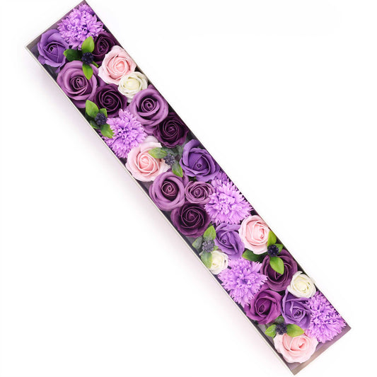 Soap flowers, arranged in a long, rectangular box, are displayed against a white background.  The flowers are various shades of purple, pink, and white.
