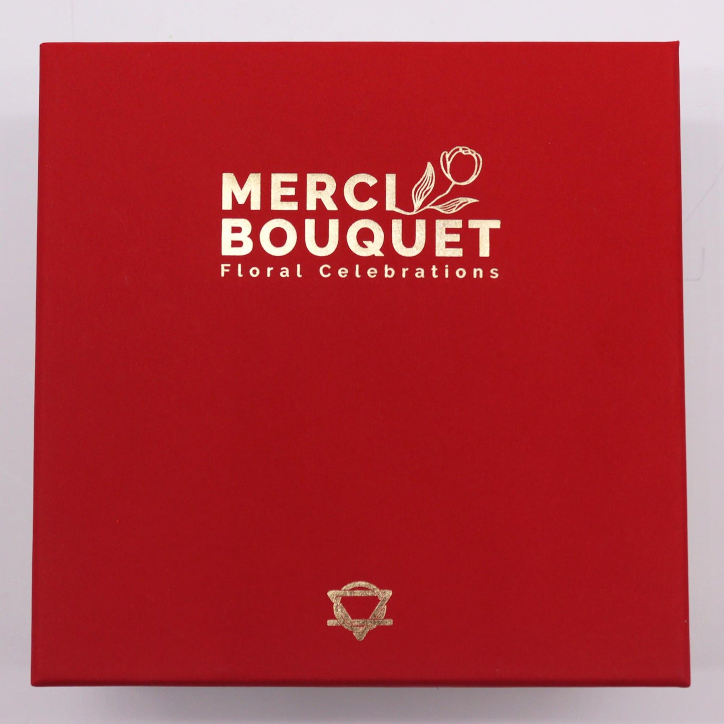 A red box displays “MERCI BOUQUET Floral Celebrations” in gold lettering and a gold logo.