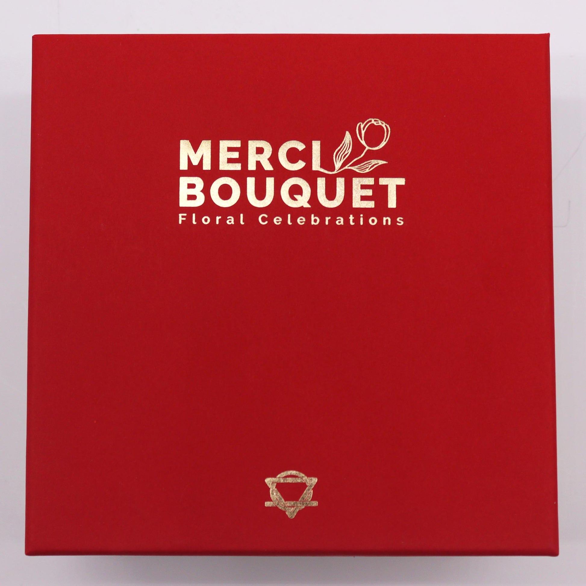 A red box displays “MERCI BOUQUET Floral Celebrations” in gold lettering and a gold logo.