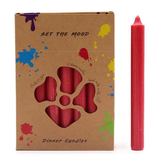 Red candles are displayed beside a cardboard box that reads “SET THE MOOD,” “21 dinner candles,” “Solid Colour,” “hand made in the UK,” and “Dinner Candles,” decorated with colorful paint splatters.