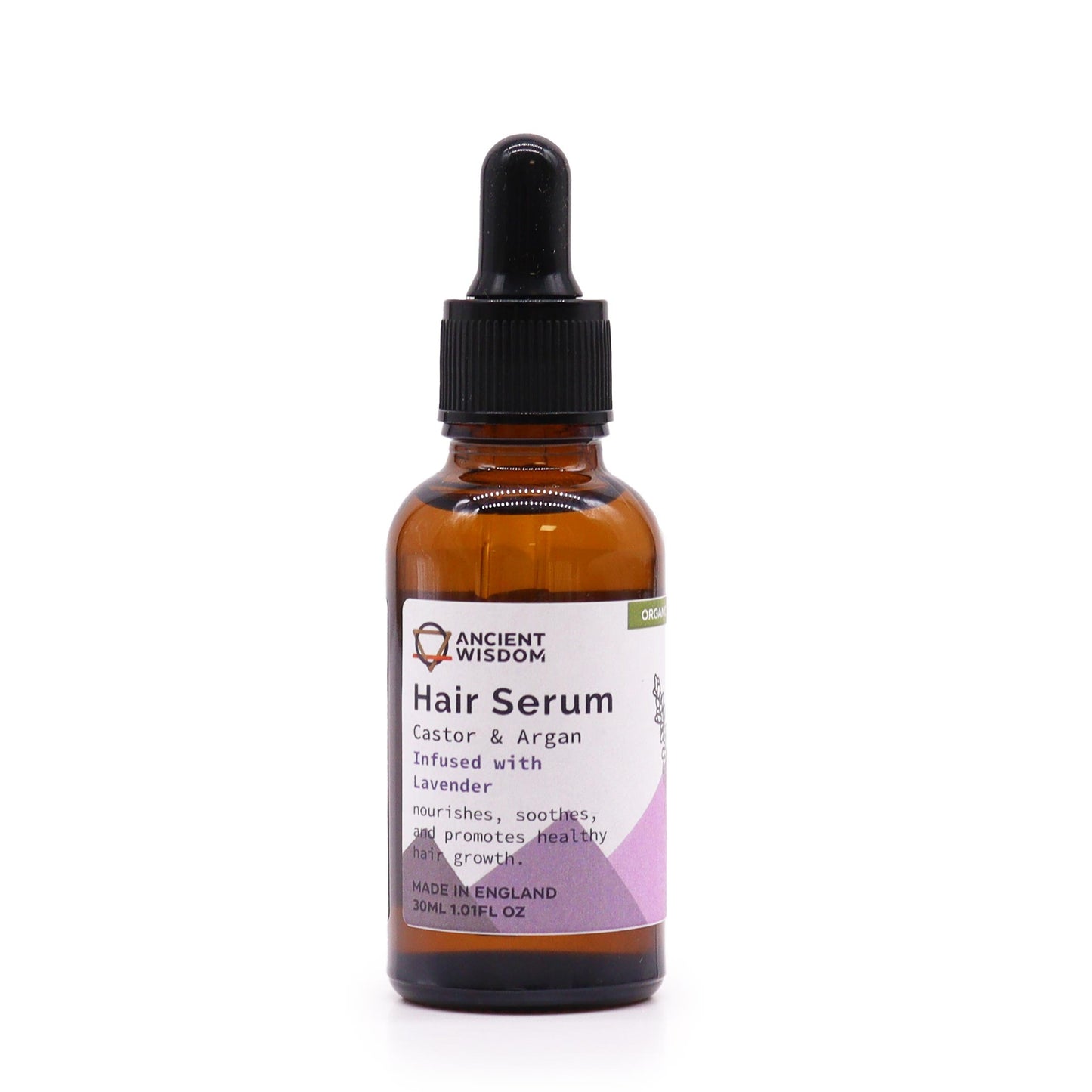 A brown glass bottle of "Ancient Wisdom Hair Serum" stands in a white space. The label reads "Castor & Argan Infused with Lavender. nourishes, soothes, and promotes healthy hair growth. MADE IN ENGLAND 30ML 1.01FL OZ".
