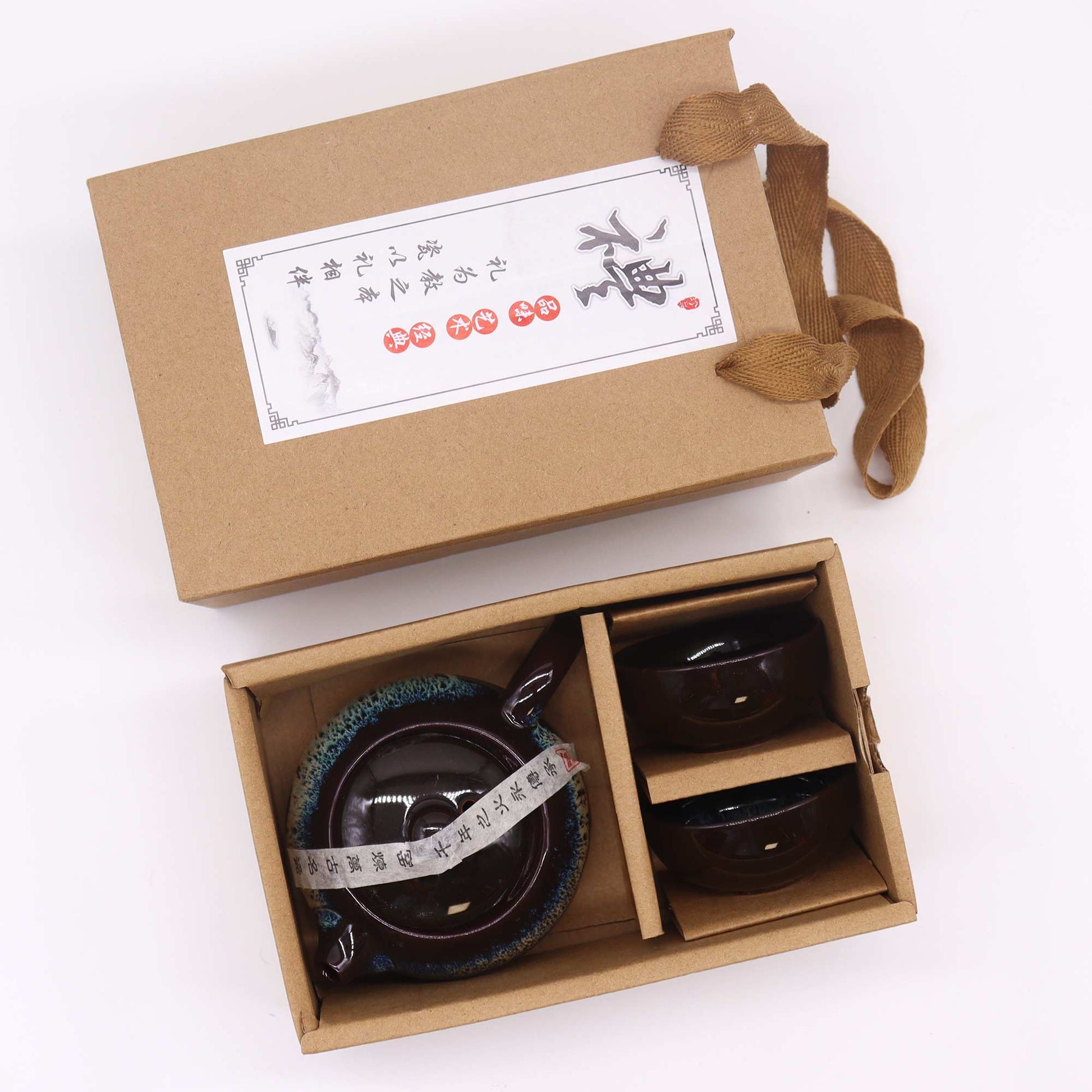 A ceramic teapot and two cups are nestled inside a brown cardboard box; the box is open, showcasing the contents.  The box includes a label with Chinese characters.