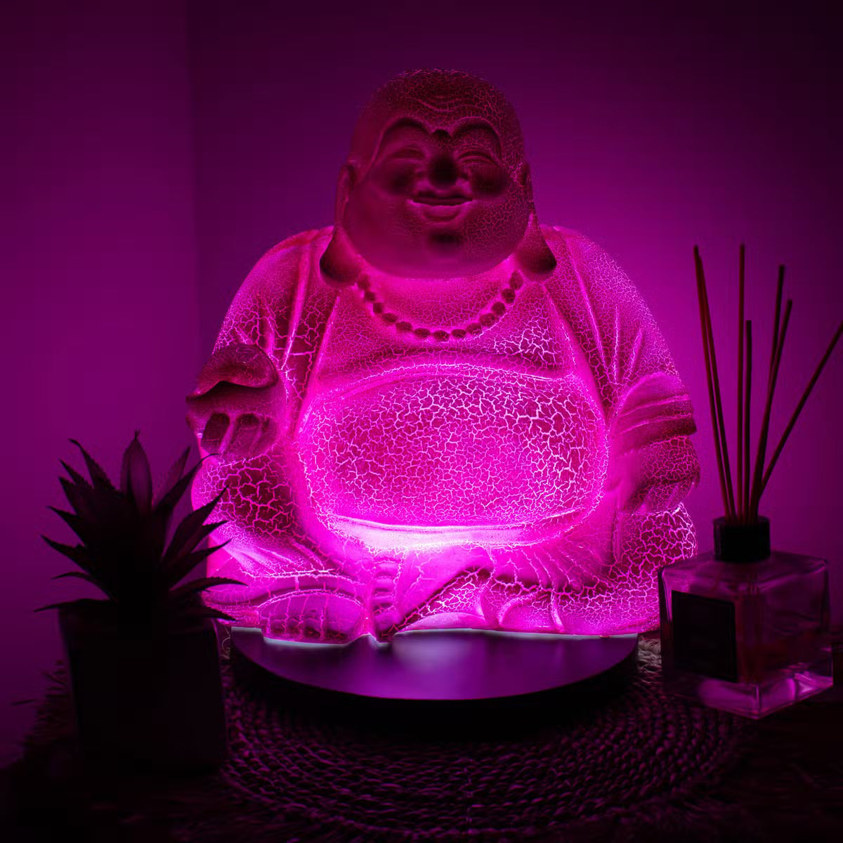 Dragonfruit Laughing Buddha lamp with vivid pink-magenta glow and black round stand UK