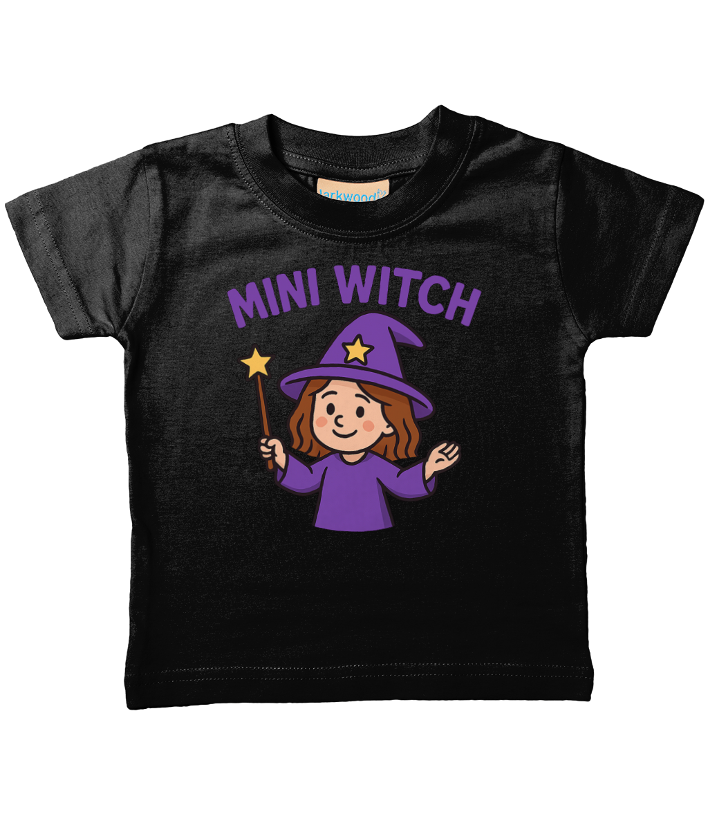 A black toddler T-shirt shows "MINI WITCH" above a smiling cartoon witch in a purple hat and robe holding a star wand on a white background; label reads "larkwood".