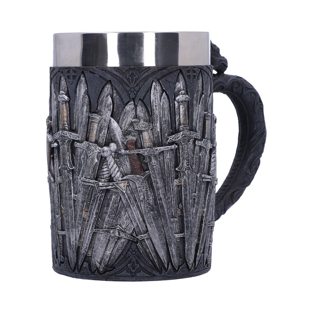 A gray tankard with a silver rim features a sculpted design of various medieval swords, standing in rows, against a dark decorative background. It is set against a plain white backdrop.