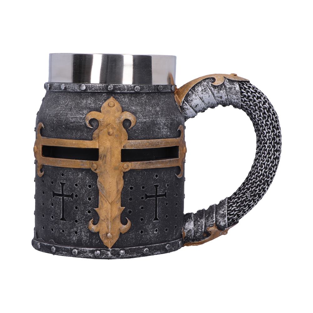 A tankard mug resembles a Crusader helmet with a silver rim. The helmet features a gold cross, and the handle looks like chain mail, all against a white backdrop.
