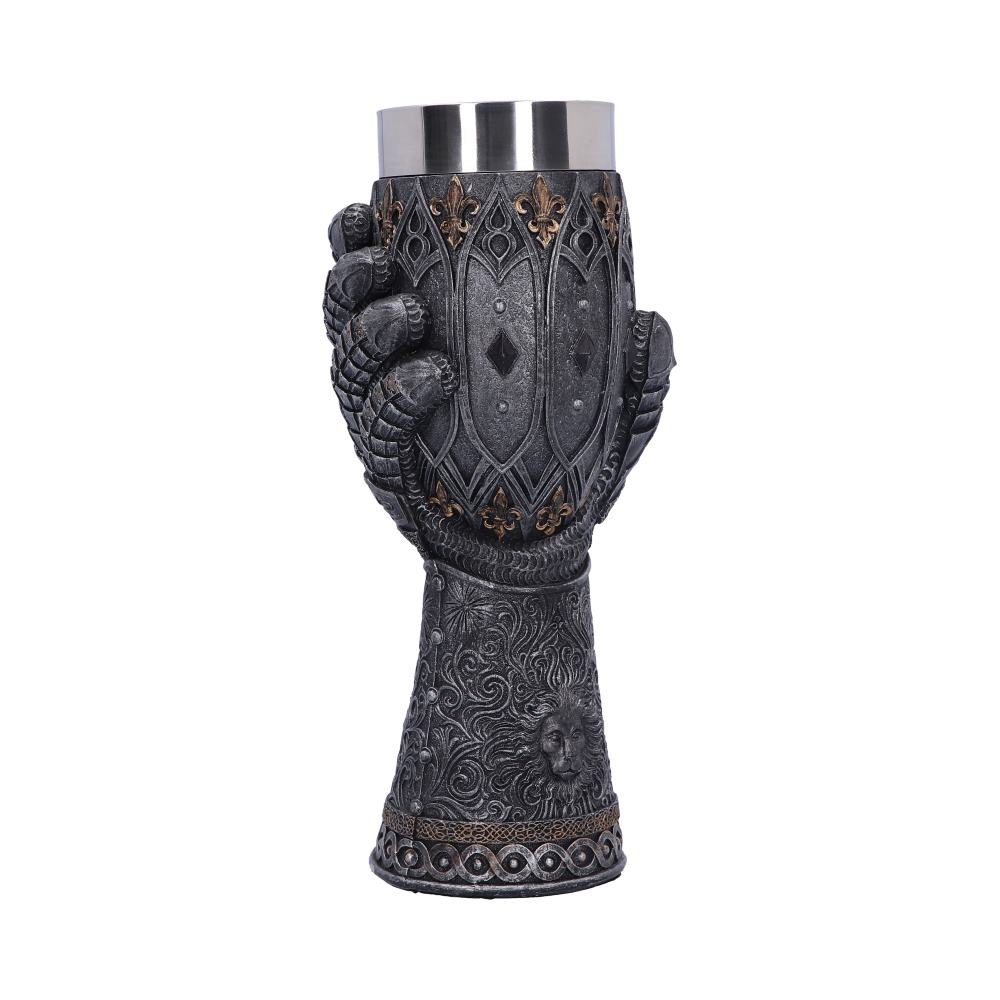 A decorative mug is held by a gauntleted hand; the mug's stem features intricate detailing including a lion head. Silver lines the mug rim against a white background.