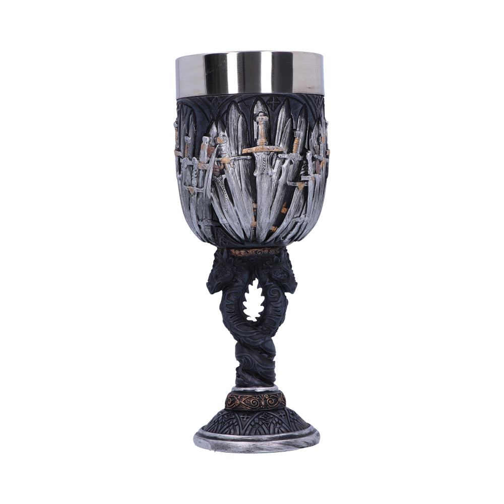 A goblet sits on a white surface. The goblet has a steel top and a body decorated with swords. A stem with entwined dragons leads to a decorative base.