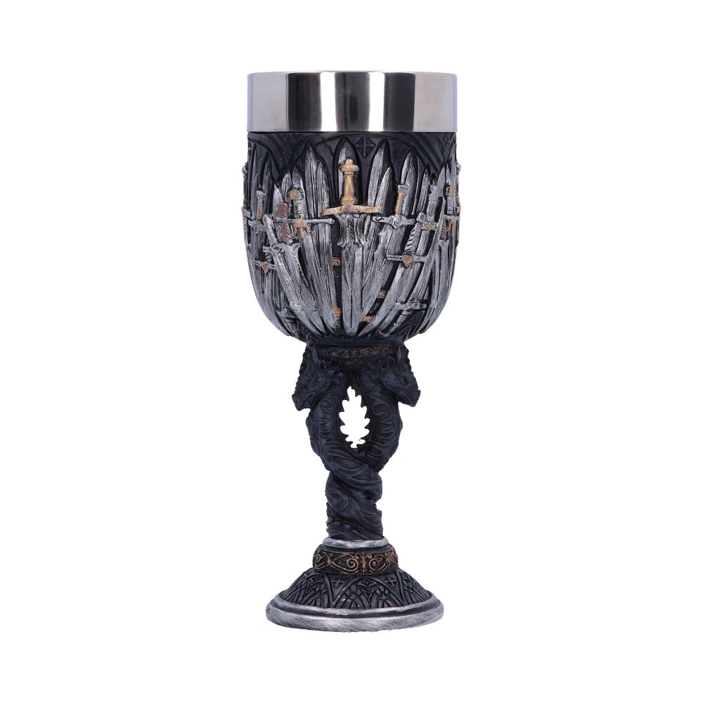 A goblet, detailed with interwoven swords, sits on a base with a decorative swirl, against a white background. The cup is silver and dark gray.