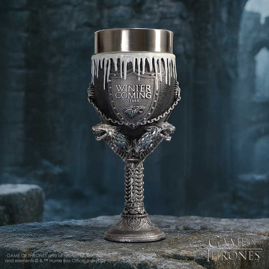Ornate metal goblet bearing a shield engraved WINTER IS COMING STARK sits on a frost-covered stone ledge in a dim icy courtyard; visible text: WINTER IS COMING STARK; GAME OF THRONES; GAME OF THRONES and all related characters and elements © & ™ Home Box Office, Inc. (s25)