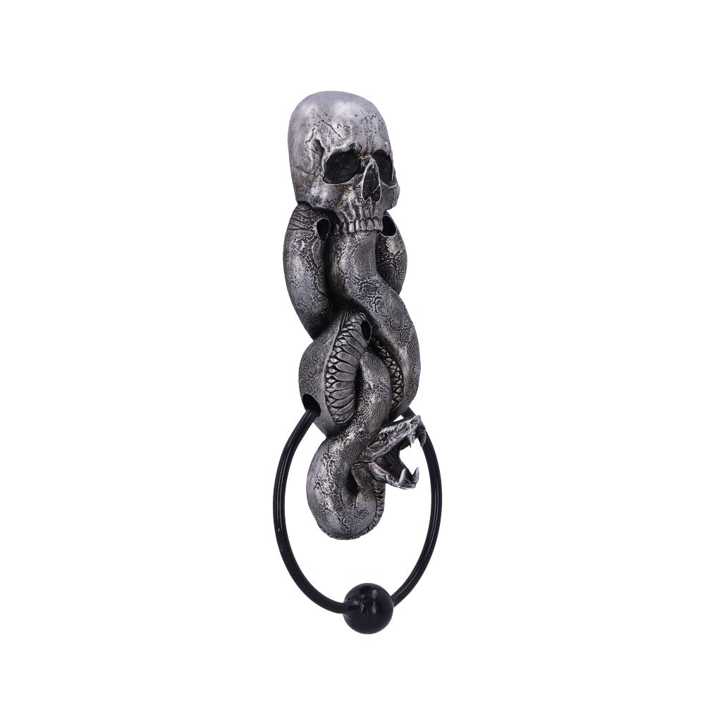 A metallic skull wall ornament features a snake coiled around it, holding a black ring in its mouth, set against a plain white background.