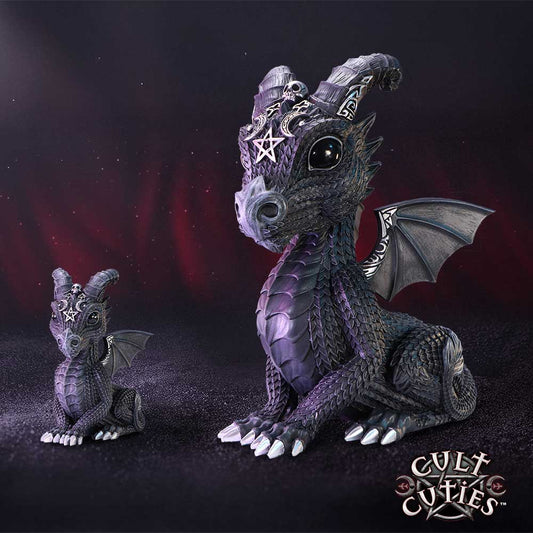 Two purple baby-dragon figurines sit on a dark textured surface, larger beside smaller, both bearing pentagram and skull head details against a red-black smoky backdrop; CULT CUTIES™