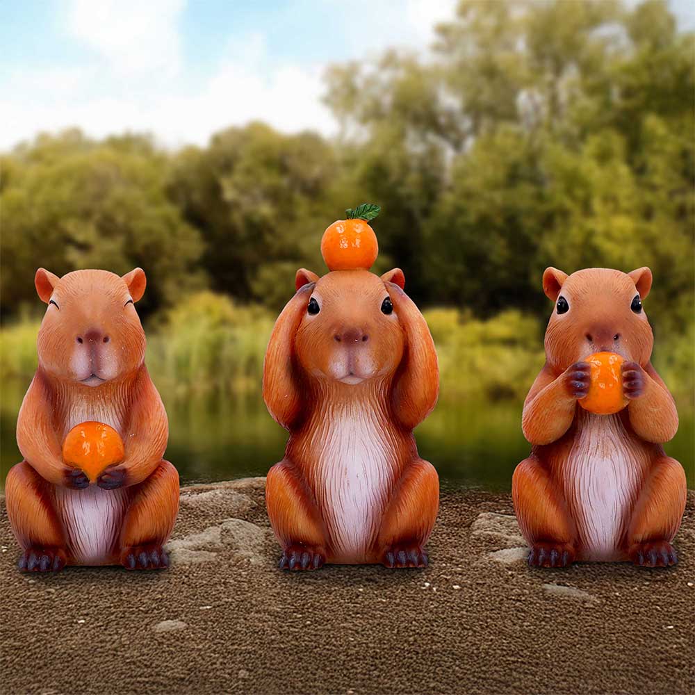 Three Wise Capybaras hand-painted resin figurine trio in See No Evil, Hear No Evil and Speak No Evil poses, each holding a bright orange