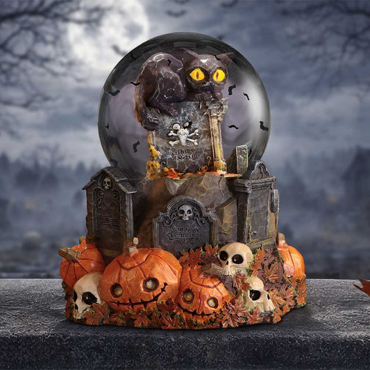 Pumpkin Patch Halloween cat snow globe by Nemesis Now with black cat on gravestone, orange pumpkins, skulls and autumn leaves